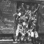 German soldiers in a railroad car on the way to the front during early World War I, taken in 1914. Taken from  site, tags: den - CC BY-SA